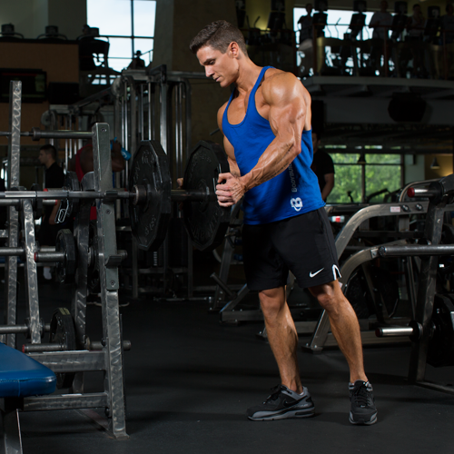 Jason Wittrock loading a weight plate onto a barbell in the gym